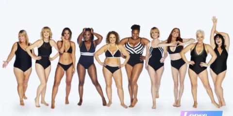 Twelve women, diverse in size and ethnicity, pose in various black swimsuits against a white background.
