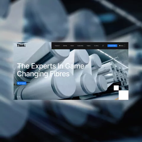 Large industrial rollers process fibres in a factory setting. The website headline reads: 'The Experts In Game Changing Fibres'.