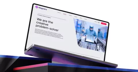 A laptop displays a website; it showcases a company's problem-solving abilities, illustrated by workers in a sterile environment. The text reads: 