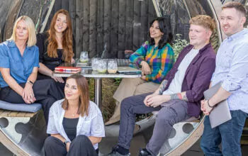 Six members of the Fishtank team in an outdoor seating booth at Arthurs Cafe