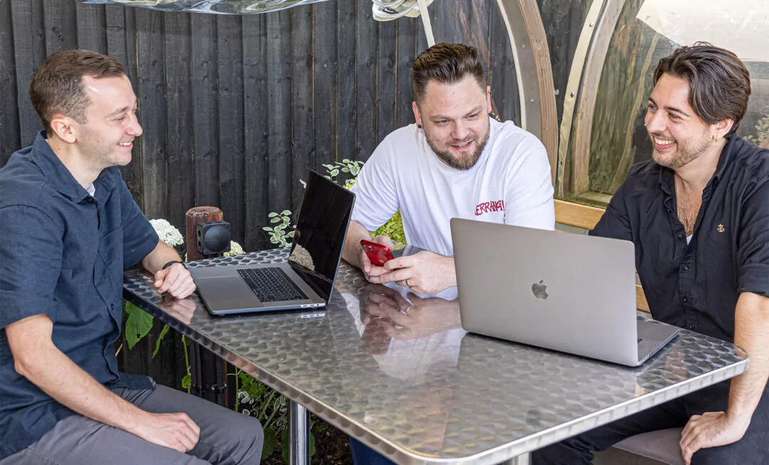 Paul Marshall, Mike Garlick and Charles De Kerckhove sitting at a table with two laptops