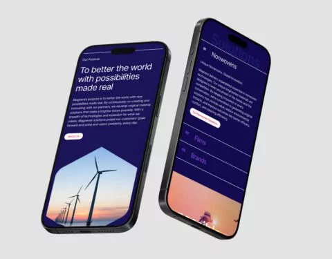 Two smartphones display a website; one shows wind turbines at sunset, the other shows text about solutions. The text includes: 