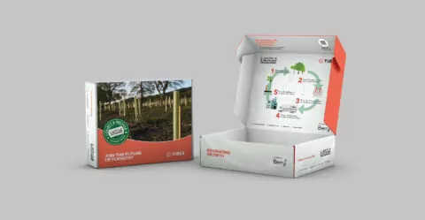Two cardboard boxes sit on a neutral background; one is closed, showing a picture of saplings, and the other is open, displaying a circular diagram.