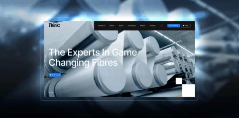 Large industrial spools of fibre are being processed in a factory setting. The website text reads: 